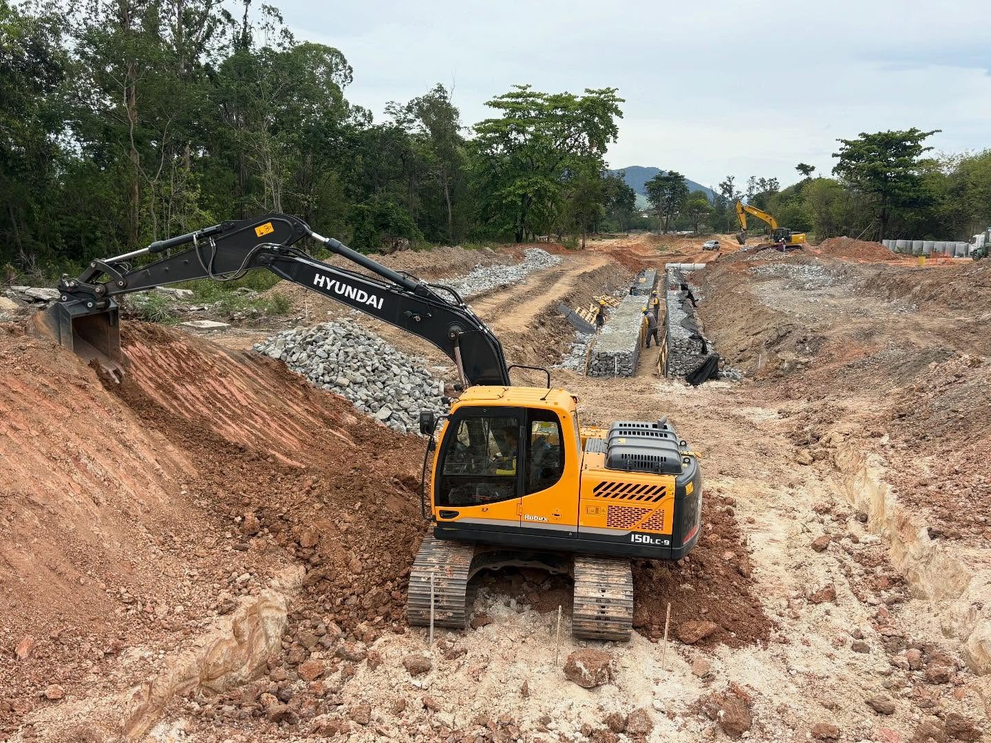 Escavadeira Hyundai trabalhando em grande obra de terraplenagem com gabiões