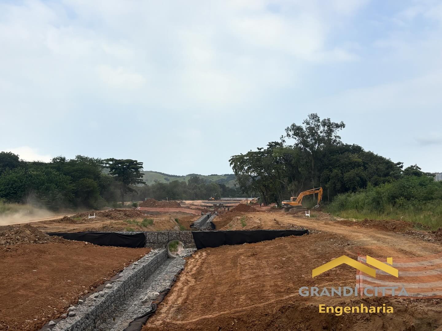Obra de drenagem com gabião e escavadeira